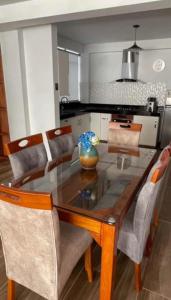 a dining room table with chairs and a kitchen at DEPARTAMENTOS SUPER AMOBLADOS CIENEGUILLA in Lima