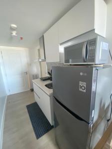 a kitchen with a microwave on top of a refrigerator at AzureNorth 17F Mt Arayat View in Del Rosario