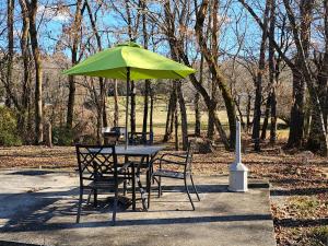 a table and chairs under a green umbrella at The Honey Bee Motel in Dunlap