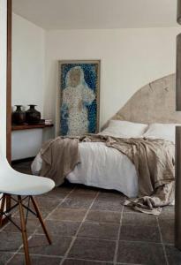 a bedroom with a bed and a chair and a painting at Villa Bianca in Massa Lubrense