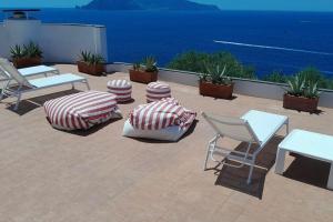 a patio with chairs and tables and the ocean at Villa Bianca in Massa Lubrense