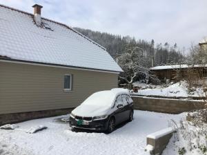 un coche aparcado en una entrada cubierta de nieve en Ferienhaus zum Rossbach 