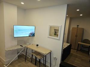 Camera con tavolo e TV a schermo piatto a parete di Luxury 1-Bed Apartment in London a Londra
