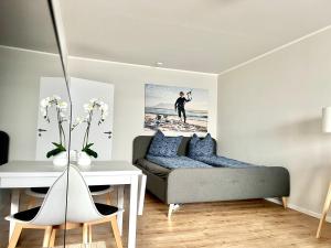 ein Wohnzimmer mit Bett und Schreibtisch in der Unterkunft WEITBLICK APARTMENT direkt am Park mit kostenlosem Parkplatz in Bremerhaven