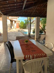 Biały stół i krzesła ze stołem i obrusem w obiekcie Casa de Veraneio com Piscina Perto da Praia w mieście Lauro de Freitas