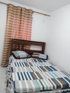 una camera da letto con un letto con una coperta e una finestra di Apartamento João Pessoa -apt completo 2 quartos casal a João Pessoa Altre 2 foto