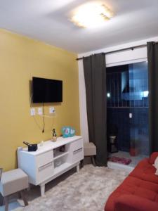 un soggiorno con TV su una parete gialla di Apartamento João Pessoa -apt completo 2 quartos casal a João Pessoa