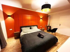 a bedroom with a large bed with orange walls at ALBA MOUNTAIN CHALETS in Gusswerk
