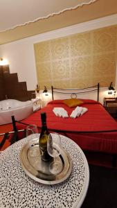 una camera d'albergo con un letto e un tavolo con una bottiglia di B&B Centrum Palmi a Palmi