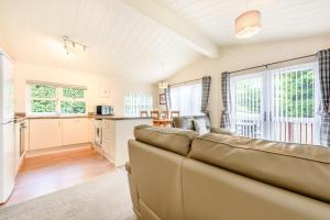 a living room with a couch and a kitchen at HB Hornbeam Lodge 05 in Narberth