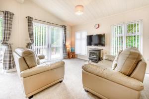 a living room with two couches and a tv at HB Hornbeam Lodge 05 in Narberth