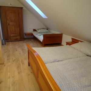 a bedroom with two beds and a wooden cabinet at Beim Bergbauer in Fischbach