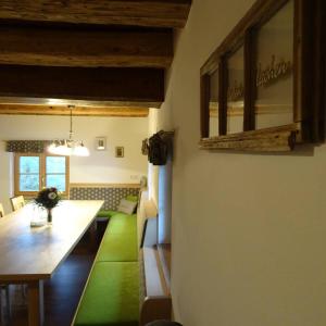una sala da pranzo con un lungo tavolo e un tappeto verde di Beim Bergbauer a Fischbach
