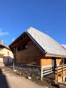 ein Holzgebäude mit einem Dach auf einer Straße in der Unterkunft La belle grange in Mercury
