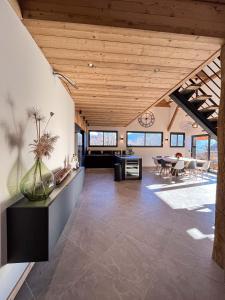 ein großes Wohnzimmer mit Holzdecke in der Unterkunft La belle grange in Mercury