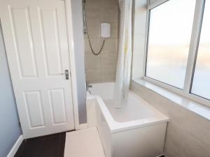 a white bathroom with a tub and a window at Lytham Place in Preston