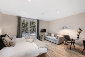a white bedroom with a large bed and a couch at The Haddon Studio - Apartment 7 in Tideswell