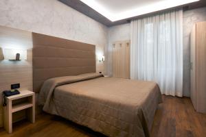 a bedroom with a large bed and a window at Hotel Galimberti in Turin