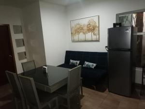 a living room with a couch and a table and a refrigerator at Casa Naty in Ciudad Valles