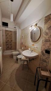 een badkamer met een wastafel, een toilet en een spiegel bij B&B Centrum Palmi in Palmi