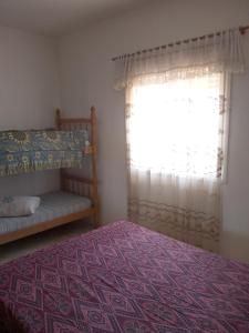 a bedroom with a bed and a window at Apartamento família perto do mar in Tramandaí +29 photos