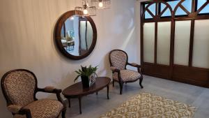 Habitación con 2 sillas, mesa y espejo. en Casa 59 - Guest House, en Bucaramanga