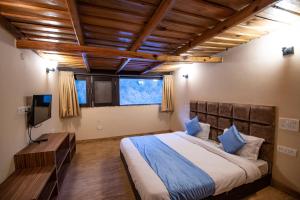 a bedroom with a large bed and a television at Allure lake front in Nainital