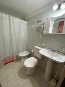 La salle de bains est pourvue de toilettes blanches et d'un lavabo. dans l'établissement Alquileres "Agus", à Las Grutas