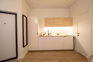 a kitchen with white cabinets and a sink at Lukiskes square apartments (Oldtown) in Vilnius