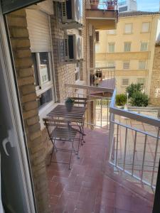 a balcony with a table and chairs on a building at Apartamento de 3 dormitorios Jardinillos Centro in Jaén