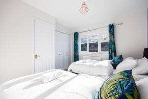 a white room with two beds and a window at Remarkable 2- Bed House in Barking Essex in Thamesmead