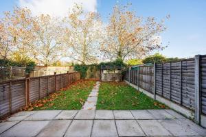 a yard with a fence and leaves on the ground at Remarkable 2- Bed House in Barking Essex in Thamesmead