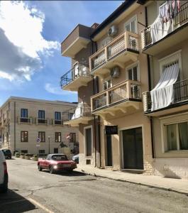 a red car parked in front of a building at San Rocco Rooms in Palmi
