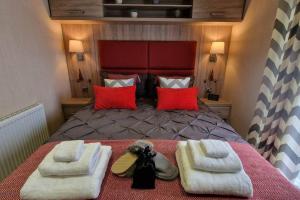 1 dormitorio con 1 cama grande y toallas. en Contemporary home at Tarka Holiday Park Barnstaple, en Barnstaple