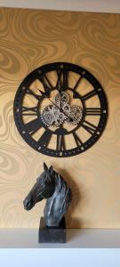 a clock on a wall with a statue of a horse at no 7 boutique apartment in Ulverston