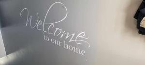 a wall with a sign that says welcome to our home at no 7 boutique apartment in Ulverston