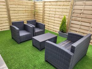 four wicker chairs and a table on a lawn at no 7 boutique apartment in Ulverston