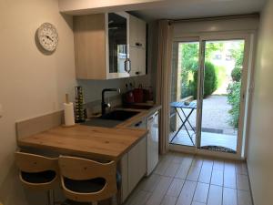 a kitchen with a sink and a table with chairs at Studio neuf de 24m² in Brive-la-Gaillarde