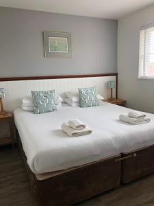 sypialnia z dużym łóżkiem z ręcznikami w obiekcie The Salty Dog holiday cottage, Camber Sands w mieście Rye