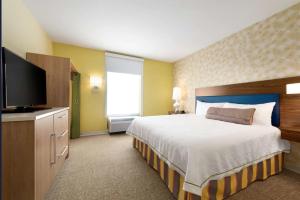 a bedroom with a large bed and a flat screen tv at Home2 Suites By Hilton-Cleveland Beachwood in Beachwood