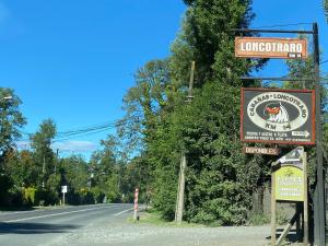 una señal para una posada de longhorn al lado de una carretera en Cabañas Loncotraro, en Pucón