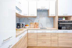 uma cozinha com armários brancos e electrodomésticos brancos em GoodWind Aparthotel - We believe in high standards em Budapeste