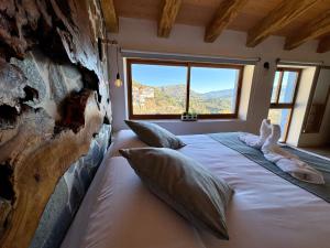 a bedroom with a large bed with a large window at La Casucha de Chulilla in Chulilla