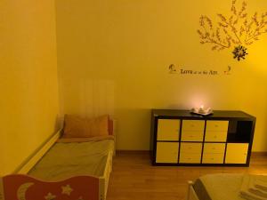 ein Schlafzimmer mit einem Bett und einer Kommode mit einer Kerze in der Unterkunft Grazioso appartamento a Osteria Nuova in Sala Bolognese