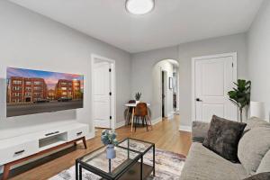 ein Wohnzimmer mit einem Sofa und einem TV in der Unterkunft Elegant 2BR Chicago Apartment - Montrose 1A in Chicago