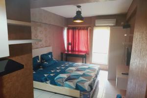 um quarto com uma cama e uma cortina vermelha em Velito at Podomoro Golf View Apartment em Kampungsitu