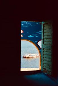 a boat in the water through a window at Heissa Hostel in Aswan