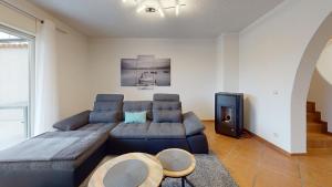 a living room with a couch and a television at Ferienhaus Hoffmann am Rheinbogen in Altlußheim