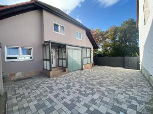 a house with a driveway in front of it at Ferienhaus Hoffmann am Rheinbogen in Altlußheim