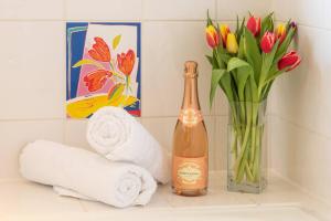 - une bouteille de champagne assise à côté d'un vase de fleurs dans l'établissement Stunning 7BR GardenVilla - Glasgow & Loch Lomond - Sleeps25 - PleasantHillScotland, à Milngavie 76 autres photos